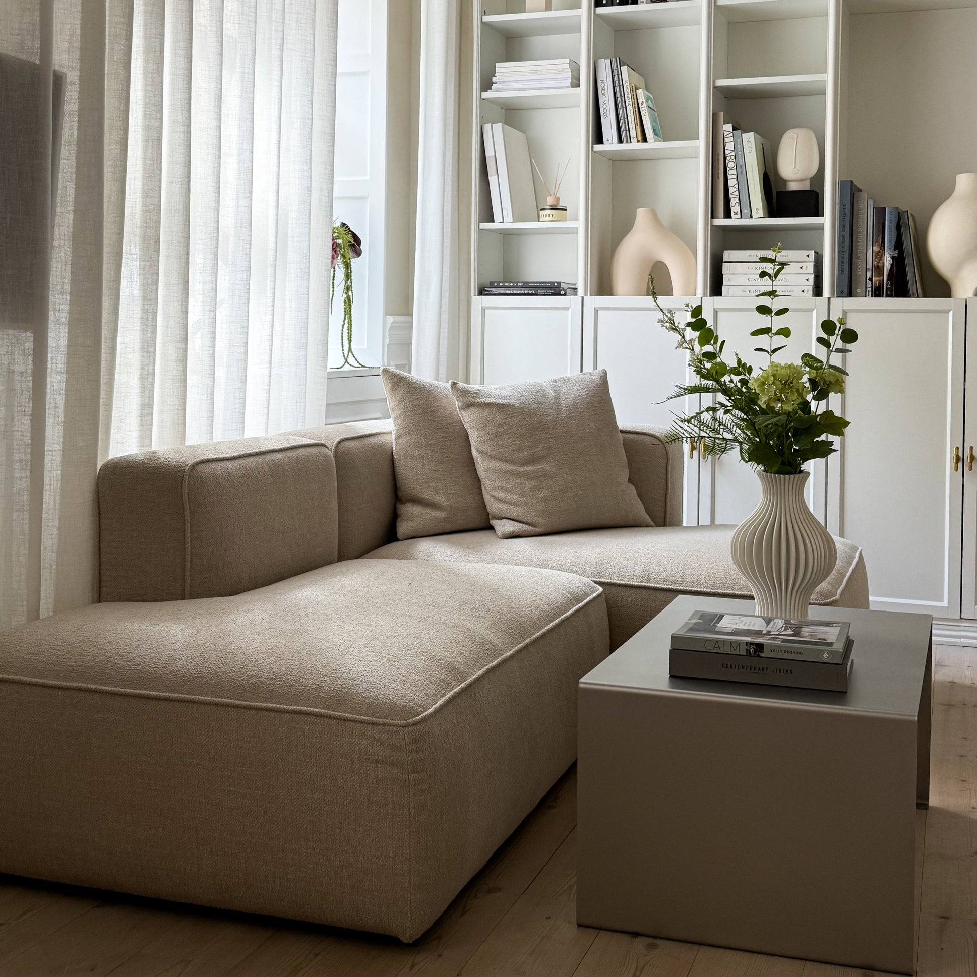Side view of the Elegance Coffee Table with a vase and shelf in the background.
